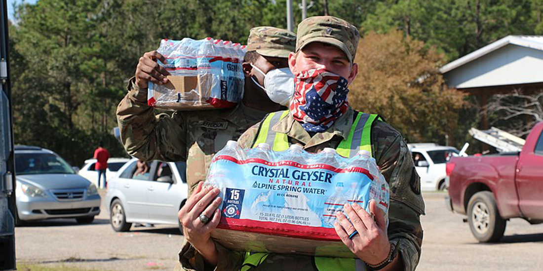 Emergency responder carrying a case of bottled water