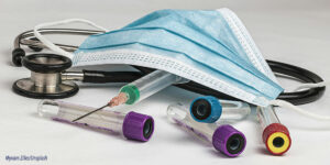 Surgical mask, stethoscope, syringe and four specimen vials