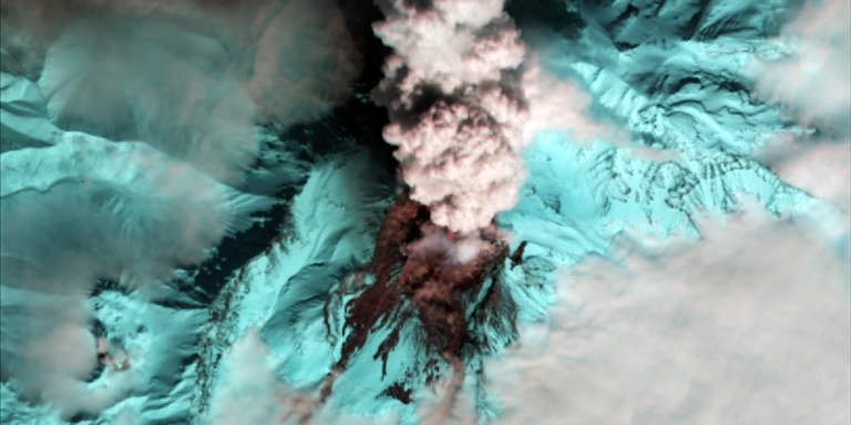 top view of live volcano in blue with smoke coming up