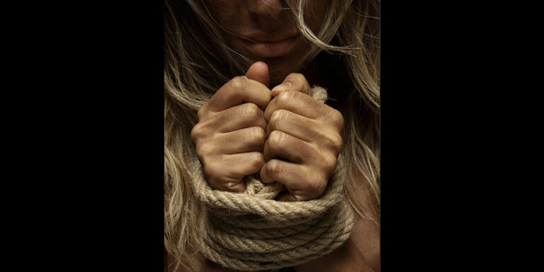 hands tied with rope in dark