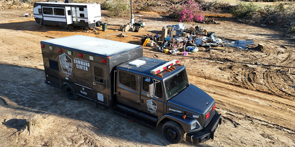 United Cajun Navy mobile command center at disaster site by trailer and debris