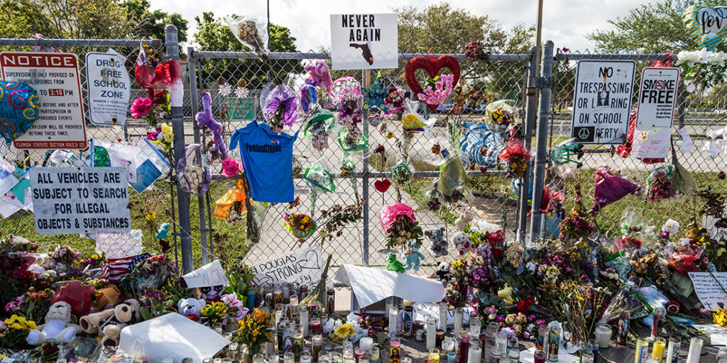 Memorial of Marjory Stoneman Douglas High School attack. Fence with flowers, candles, and notes.